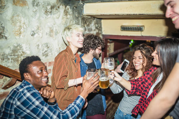 istock Group of friends spending time together, drinking beer in the pub 1129077967