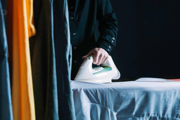 istock A woman irons clothes. Low key photo 1129078068