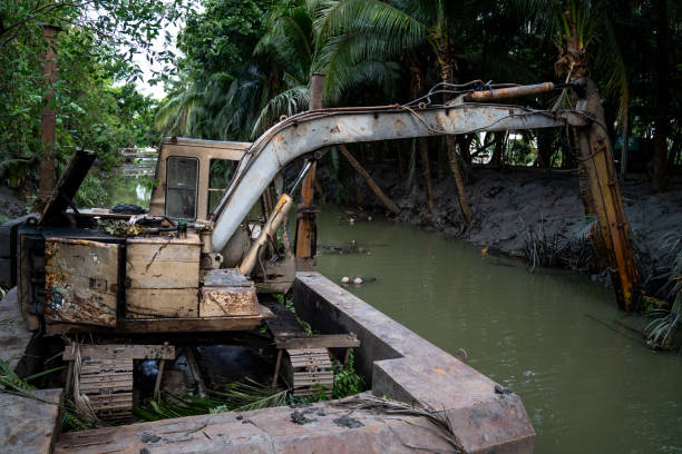 istock old loading and digging excavator on the holding water surface for digging soil in the canal 1129078076