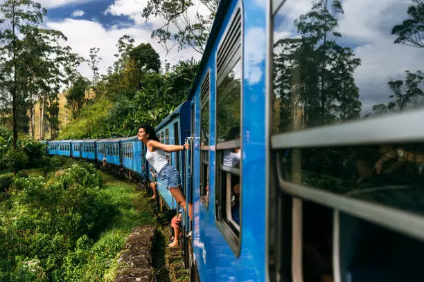 Photo of The girl travels by train to beautiful places. Beautiful girl traveling by train among mountains. Travel by train. Travelling to Asia. Trains Sri Lanka. Railway transport. Railway. Transport Asia