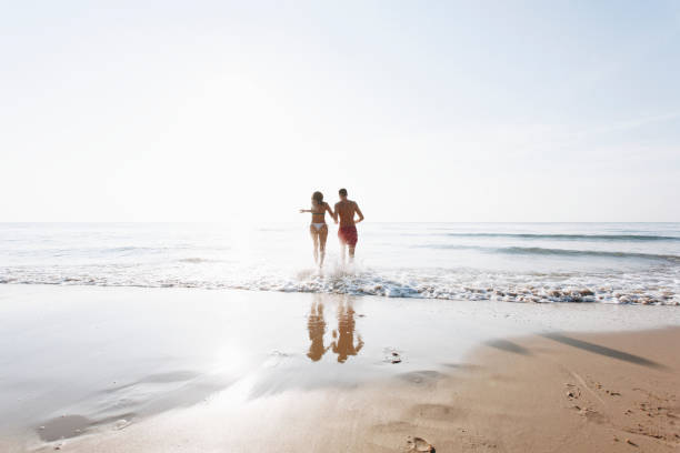 istock Cheerful couple running at the shore 1129080212