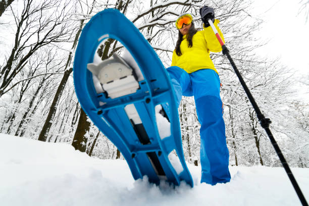 istock Mountain hiker taking big strides in the deep snow using her snowshoes and walking poles 1129081456