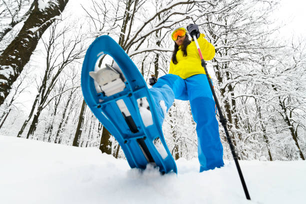 凍結の森林の深い雪の中彼女のスノーシューの大きな一歩を取って山旅行 - stepping ストックフォトと画像