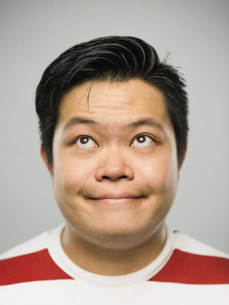 istock Real chinese young man with happy expression looking up 1129081552