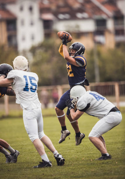 istock Determined American football player catching a ball during the game. 1129083773