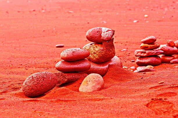 well-balanced stones in the sand on coral background