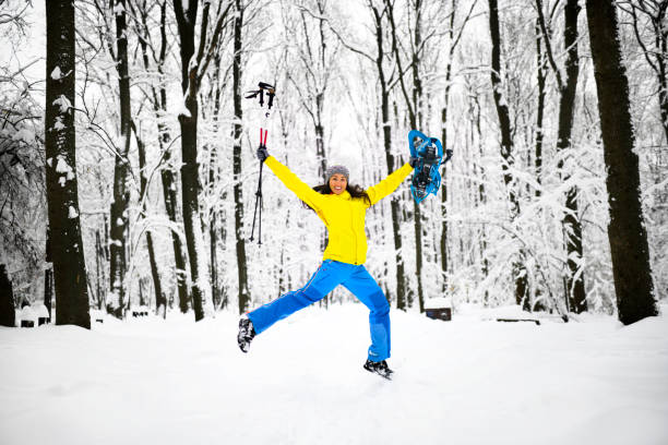 feminino caminhante pulando alegremente no meio de uma floresta congelada idílica - exploration mountain ice jumping - fotografias e filmes do acervo