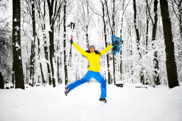 туристка радостно прыгает посреди идиллического замерзшего леса - exploration mountain ice jumping стоковые фото и изображения