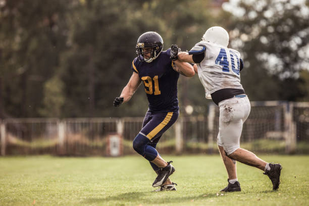istock American football player trying to avoid his opponent on a match. 1129084356