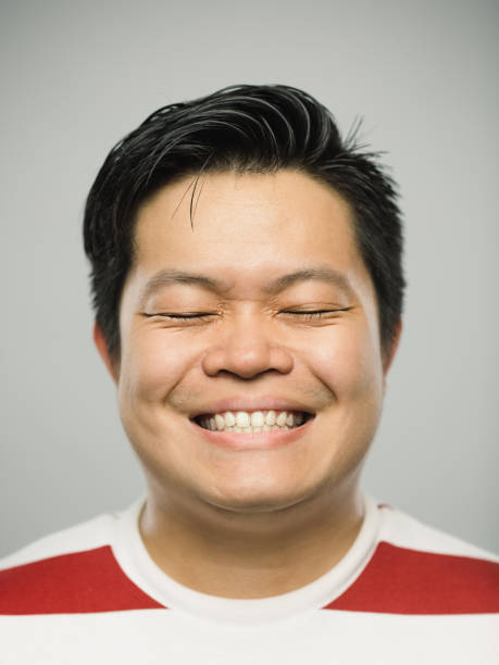 istock Real chinese young man with excited expression and closed eyes 1129084431