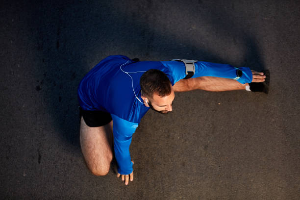 istock Top view man stretching legs on the street. 1129086357