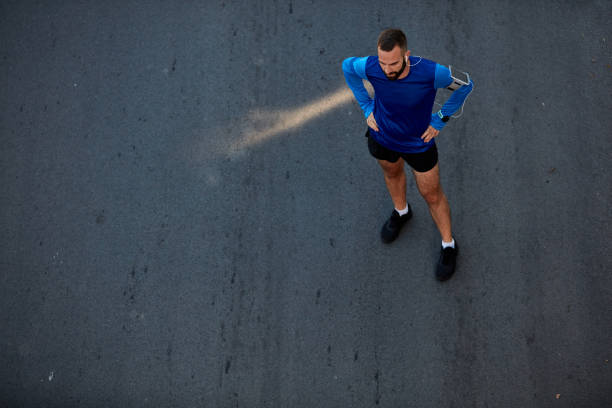 istock Runner standing on the street with hands on hips. 1129086471