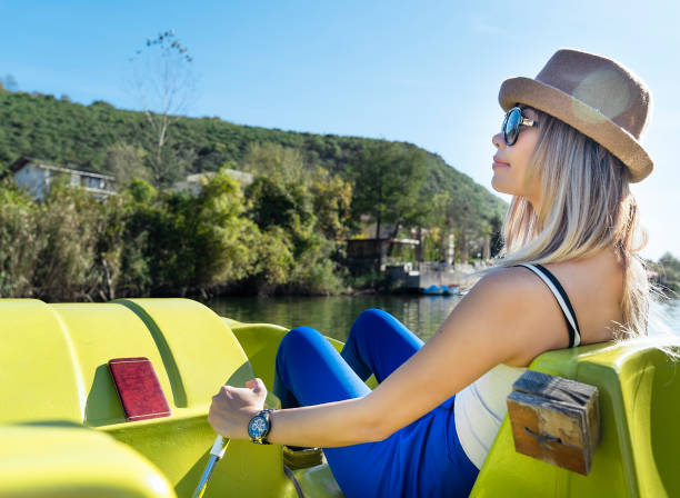 Woman paddling pedal boat on river