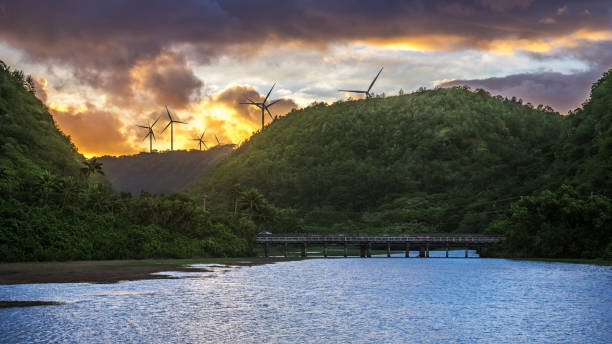 Wind power plants behind mountains of the north shore of Ohau, Hawaii Wind power plants behind mountains at sunset of the north shore of Ohau, Hawaii north shore stock pictures, royalty-free photos & images