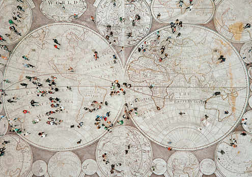 Crowd walking on global map. Composition made with antique map from 1779. Image was taken with a Sony Alpha A7RIII and made a composition with an image taken with a Mavic Pro I with Photoshop.