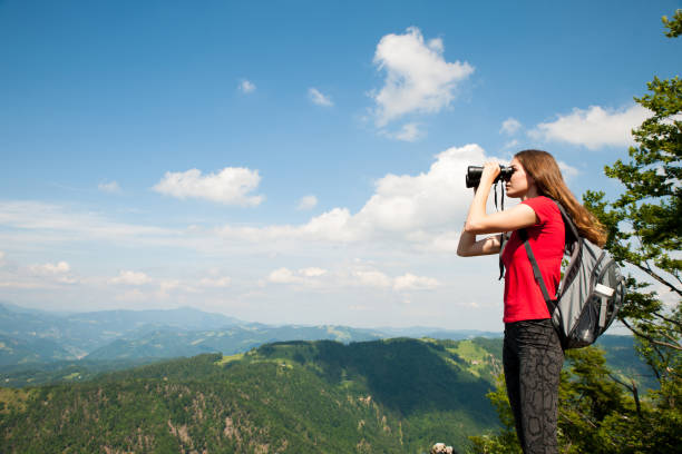 istock active Young woman looking a mountain landscape with Binoculars 1129089880
