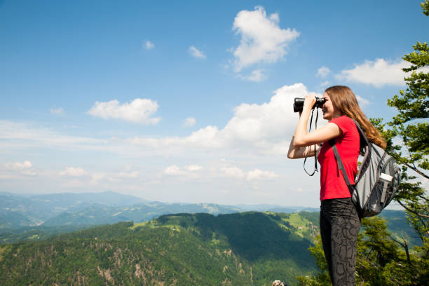 istock active Young woman looking a mountain landscape with Binoculars 1129089881
