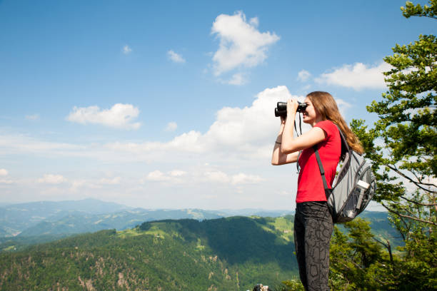 istock active Young woman looking a mountain landscape with Binoculars 1129089882