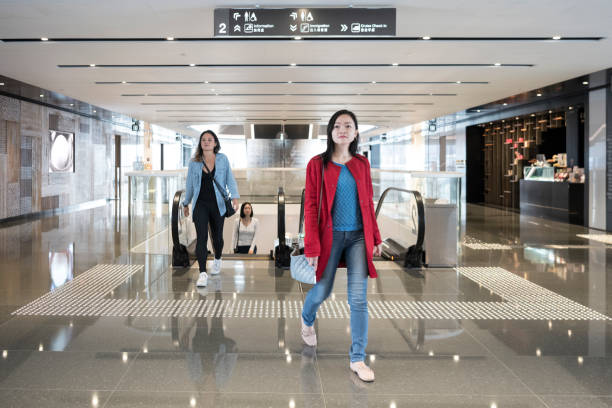 istock Chinese women by escalator in shopping mall 1129092421