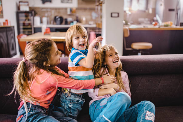 istock Small happy kids having fun while playing on sofa at home. 1129093322