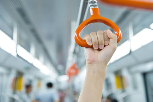 Human hand holding handle in the subway train