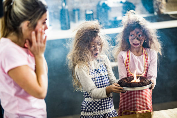 Small girls with messy hair and face baked a burnt cake while their mother is in shock.
