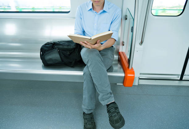 Businessman reading a book in subway train