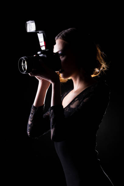 fotógrafo sujete la cámara con flash externo - low key lighting flash fotografías e imágenes de stock