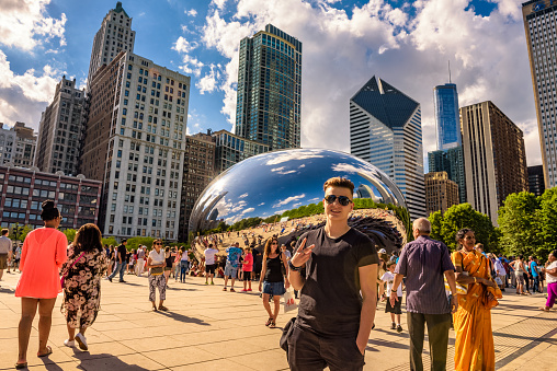 Chicago, Illinois, USA - May 29, 2016 : Tourists walking in the Millennium Park around the Cloud Gate, also known as the Bean, which is one of the parks major attractions.