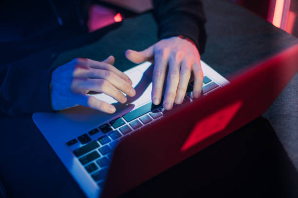 istock Hacking and criminal concept.A hacker in a secret hiding place is neon light. 1129099885