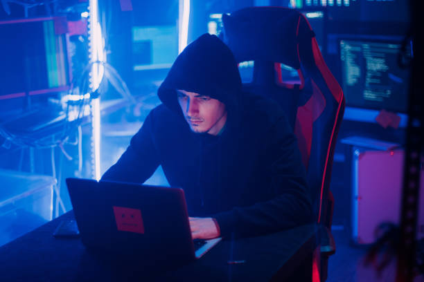 istock Hacking and criminal concept.A hacker in a secret hiding place is neon light. 1129099888