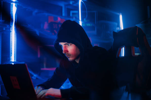 istock Hacking and criminal concept.A hacker in a secret hiding place is neon light. 1129099907