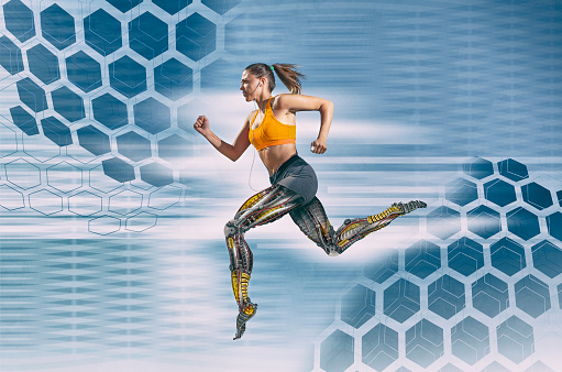 Beautiful female athlete with artificial robotic legs running fast