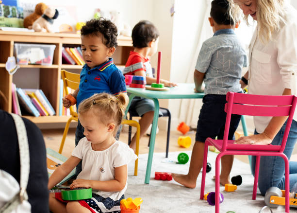 istock Nursery children playing with teacher in the classroom 1129102895