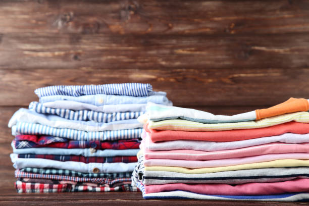 istock Stacks of folded clothes on wooden background 1129104232