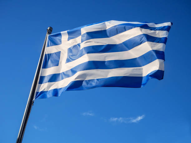 istock Greek flag waving in blue sky in Greece 1129106591