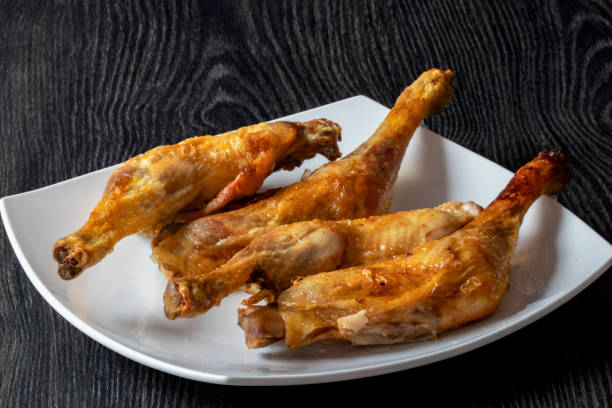 Roasted chicken thighs on a white plate Indoor shooting at 100 mm macro, 200 iso, f 22, 2 seconds grillade stock pictures, royalty-free photos & images