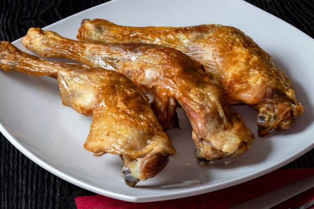 Roasted chicken thighs on a white plate Indoor shooting at 100 mm macro, 200 iso, f 22, 13/10 second grillade stock pictures, royalty-free photos & images