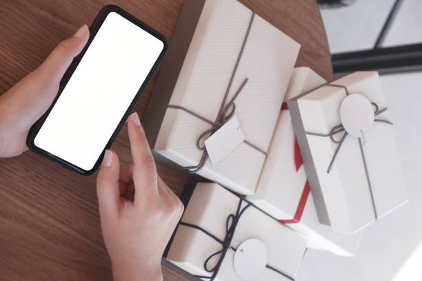istock close-up hand using smartphone for shopping online,  gift box on table, shopping for presents. 1129109717