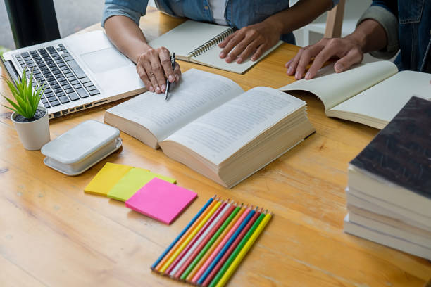 istock Education concept. Students studying and brainstorming campus concept. Close up of students discussing their subject on books textbooks and writing to notebook. Selective focus. 1129109866