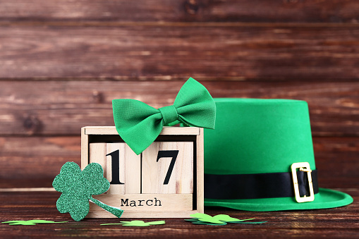St. Patrick's Day. Green hat with clover leafs, wooden calendar and bow tie