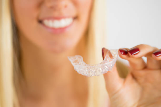 istock Woman holding teeth whitening tray 1129110602