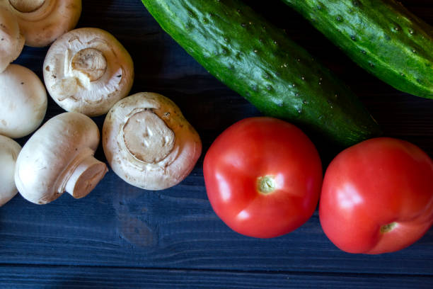istock Vegetables on a table. Mushrooms, tomatoes and cucumbers on a blue rustic background. 1129113208
