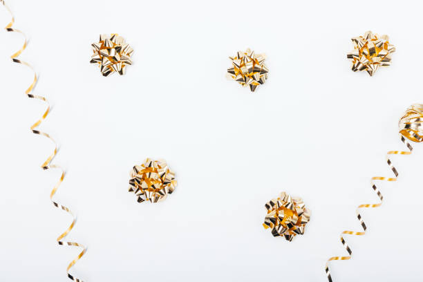 istock Golden bows and streamers on white table 1129113457
