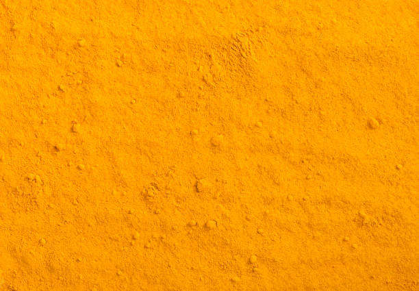 Texture in polvere di curcuma. Sfondo speziato di curcuma gialla. - foto stock