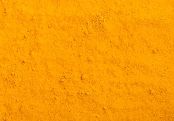 Turmeric powder texture. Yellow curcuma spice background.