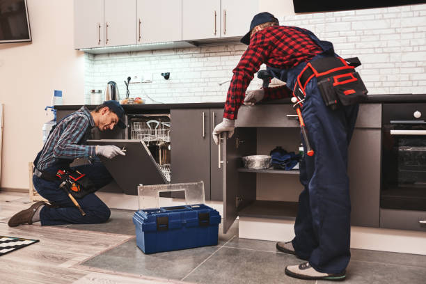 apprendre des meilleurs. technicien deux hommes s'asseyant près du lave-vaisselle - holding screwdriver photos photos et images de collection