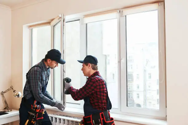 Photo of Quality light. Construction workers installing new window in house