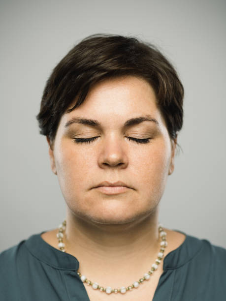 Real caucasian adult woman with blank expression and closed eyes stock photo