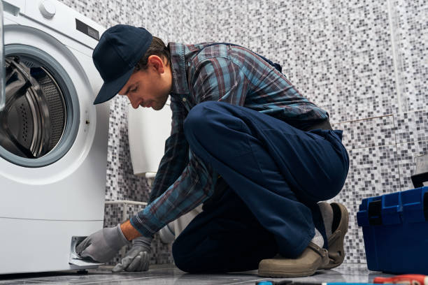 istock Attantive worker. Working man plumber in bathroom checking washing mashine 1129117523
